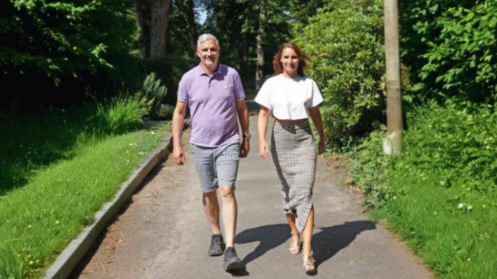 Das Bild zeigt zwei Personen – eine Frau und einen Mann – die bei sonnigem Wetter entspannt auf einem Weg durch eine grüne Parklandschaft gehen. Ihre Körpersprache ist offen und zielgerichtet, was symbolisch für Stabilität und Zuversicht steht. Im Kontext von Resilienz im Change Management visualisiert das Motiv den gemeinsamen, positiven Umgang mit Veränderungen: Schritt für Schritt, mit Klarheit und Vertrauen – zentrale Elemente für resiliente Führung in Transformationsprozessen.
